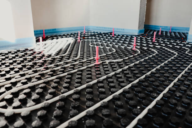 istock Installing underfloor heating system with white pipes on black styrofoam insulation 2206040375