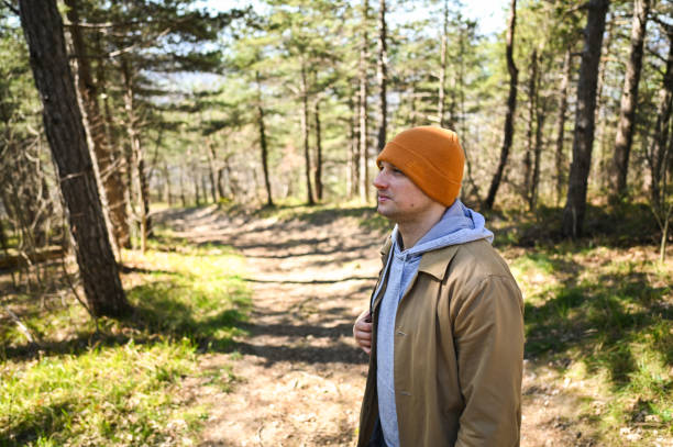 Young man walking on a path in the woods enjoying nature