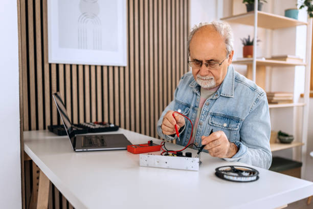 istock Casually clothed senior man working with electronics from home while following instructions on his laptop 2206044628