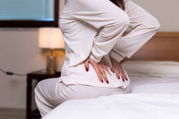 istock Woman suffering from back ache on the bed 2206044745