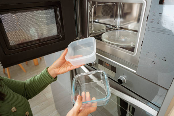 Woman Setting Temperature Of Baking Pizza Slice In Microwave Oven