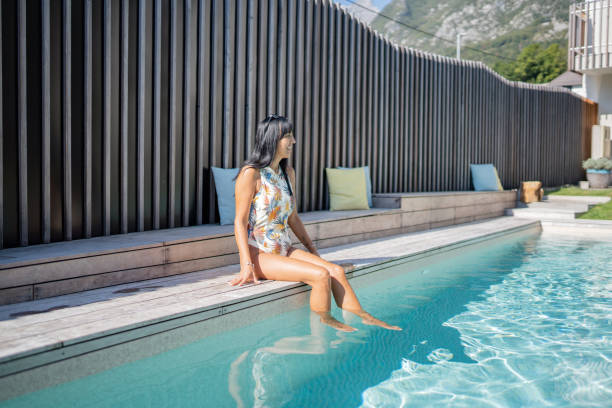 istock Hispanic Woman Relaxing by Poolside on Sunny Vacation 2206047025