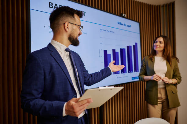 istock Businessman showing bar chart on presentation screen during meeting 2206047143