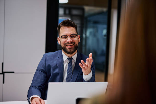 istock Businessman smiling and gesturing while talking to a colleague in the office 2206047295