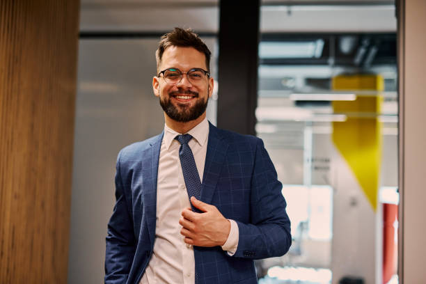 istock Smiling businessman adjusting his suit in modern office 2206047310
