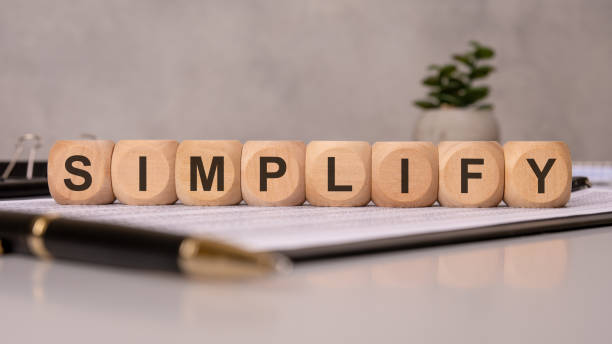 istock Wooden cubes spelling SIMPLIFY on office documents, symbolizing efficiency, clarity, and minimalism 2206047318