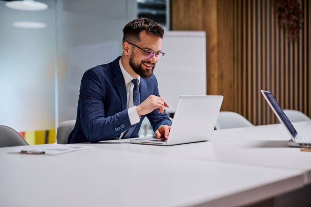 istock Businessman working on laptop in modern office smiling 2206047623