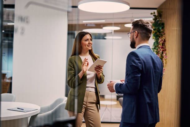 istock Businesswoman using digital tablet explaining project to businessman in office 2206047681