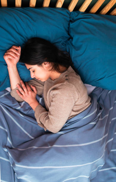 Young Woman Peacefully Sleeping in a Cozy Bed With Blue Linens