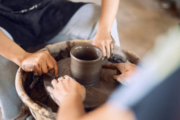 istock Hands of craftsman artist working on pottery wheel. 2206048097