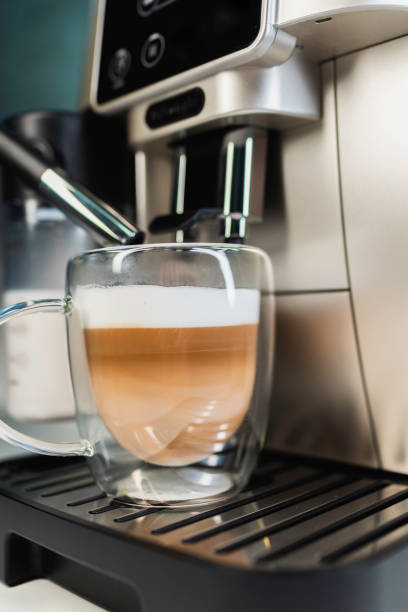 istock Home coffee maker pouring cappuccino into glass mug in kitchen 2206048661