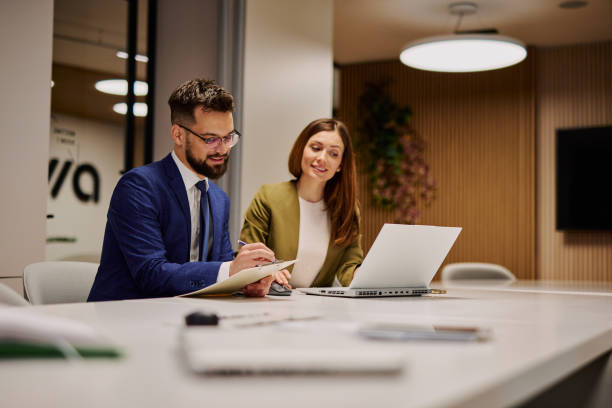 istock Business people working together in modern office using laptop and taking notes 2206048951