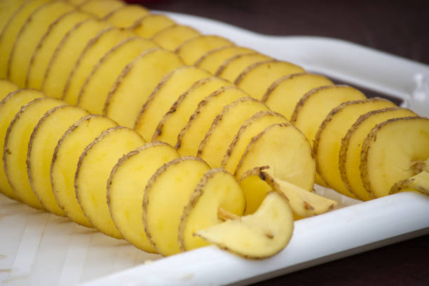 Rows of spiral-cut potatoes, arranged artfully on a white platter, offer a unique snack or side dish option, perfect for events.