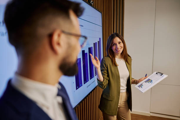 istock Businesswoman presenting marketing data on interactive whiteboard during a meeting 2206048978
