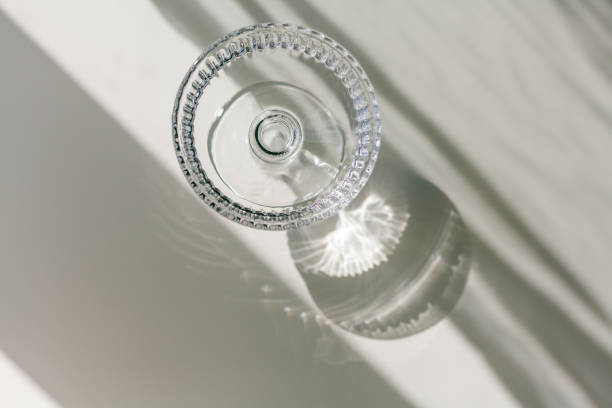 The background is white with shadows from a crystal glass.