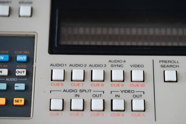 Close-up of a vintage reel-to-reel tape recorder with metal knobs and sliders.