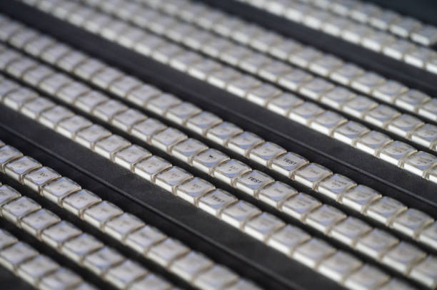 A close-up view of a professional broadcast switcher panel featuring numerous illuminated buttons arranged in rows. The monochrome look emphasizes the complexity and functionality of live video production equipment. The tactile buttons highlight precision control in television and media broadcasting.