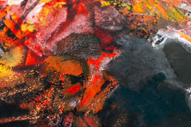 A close-up of an abstract painting featuring bold strokes of red, orange, and black. The thick, textured paint creates a dynamic and expressive composition, evoking energy and intensity. The contrast between warm and dark colors adds depth and complexity to the artwork.