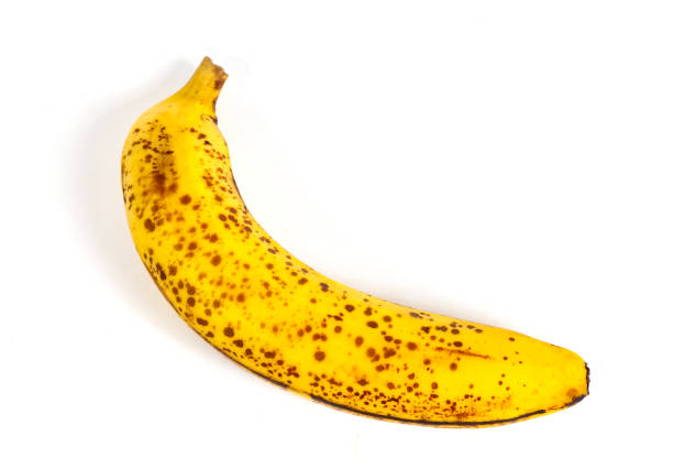 Ripe banana fruit with black spots isolated on white background