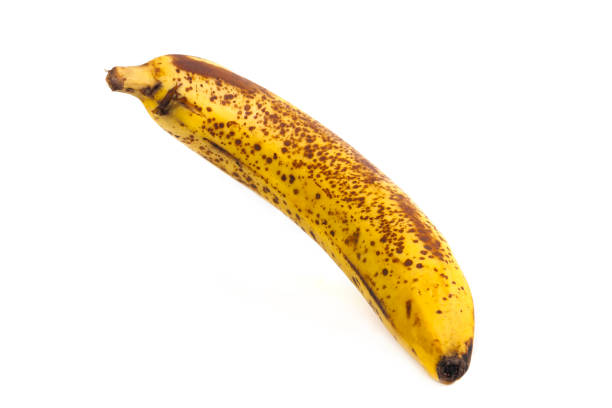 Ripe banana fruit with black spots isolated on white background