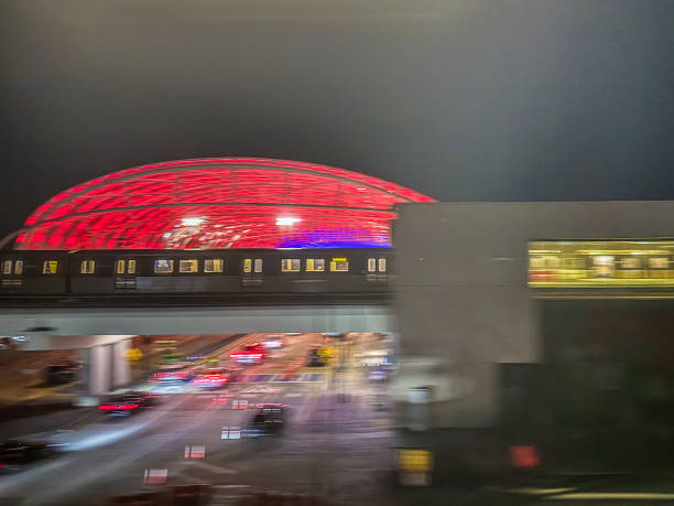 Chicago, IL, USA April 18 Passengers moving between terminals at Chicago O'Hare International Airport walk under a colorful neon light display above the people mover