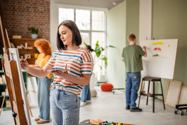 istock Group of young artists creating vibrant paintings in a spacious art studio filled with inspiration and collaboration 2206060619