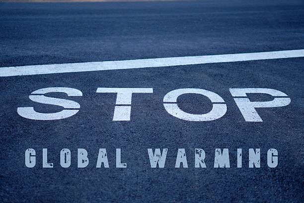 istock stop global warming concept. road sign with message written on the asphalt. 2206060976