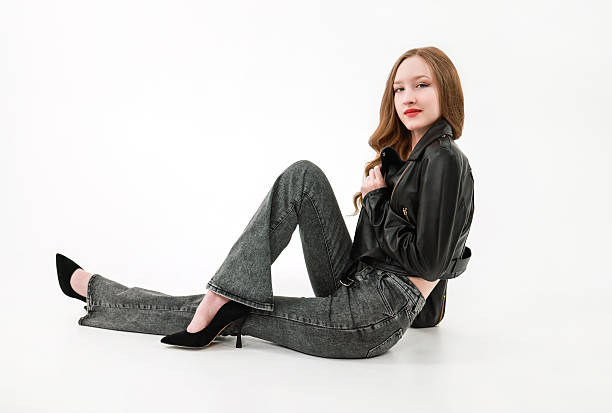 istock A girl in a leather jacket and jeans on a white background. 2206062636