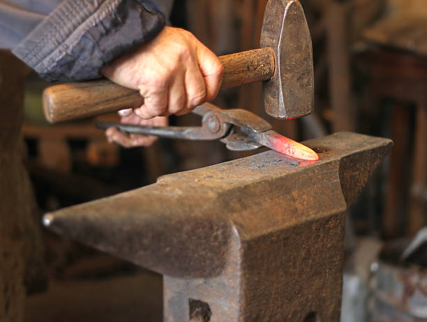 istock Blacksmith forging red-hot metal bar in smithy 2206065059