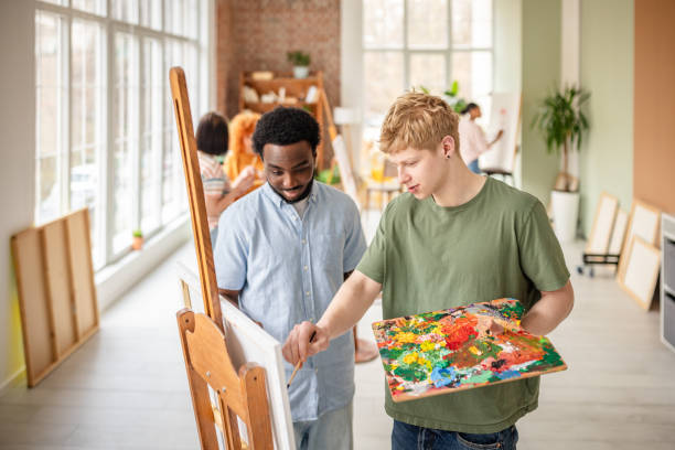 istock Young artists collaborate in a vibrant art studio, sharing creative insights and techniques during a lively workshop session 2206065949