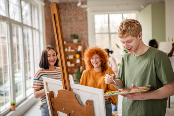 istock Young artists collaborate in vibrant art studio, creating colorful paintings and sharing inspirations in a joyful environment 2206066824