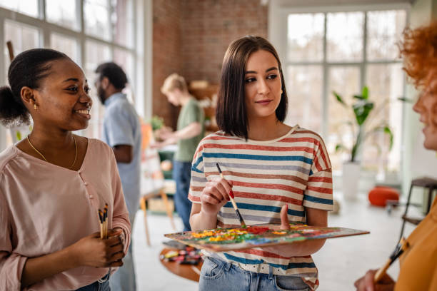 istock Young artists collaborating and sharing ideas in a vibrant art studio space during a creative workshop 2206067316