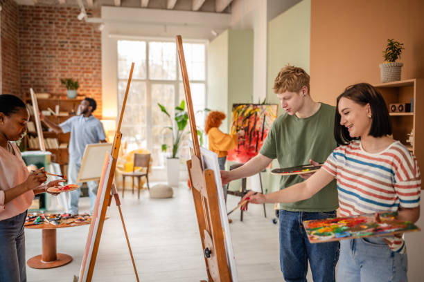 istock Young artists creating vibrant paintings in a creative studio during an inspiring art class with professional guidance 2206069018