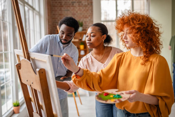istock Young artists engage in creative painting workshop in a vibrant art studio with natural light 2206070091