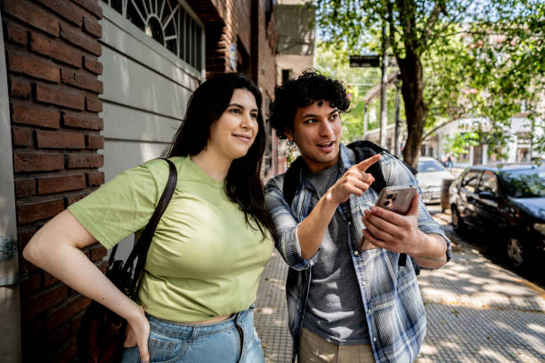 Tourist couple using mobile phone on street