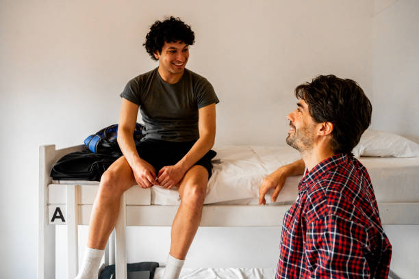 istock Male friends talking in a hotel room 2206072238