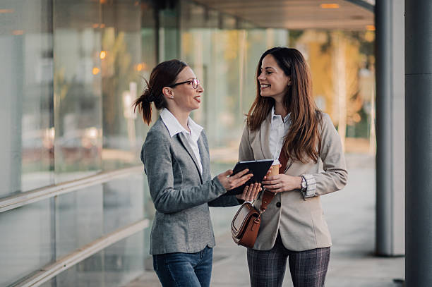 istock Businesswomen walking and talking outside office building 2206073111