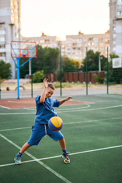 istock Boy in a blue tracksuit playing basketball 2206074052