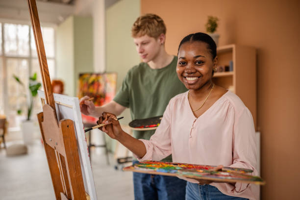 istock Young artists express creativity in collaborative art studio session with vibrant colors and inspired smiles 2206074391