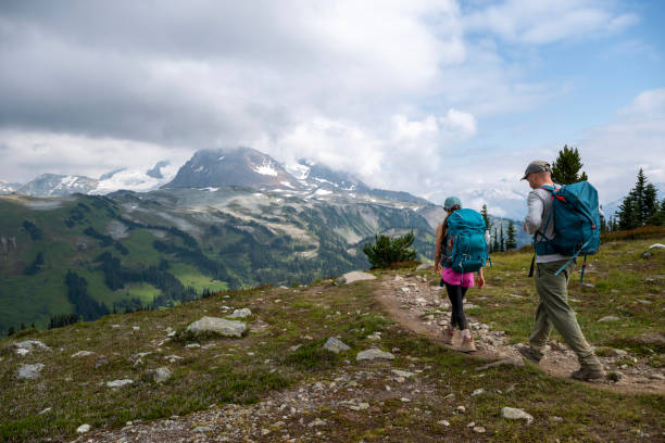istock Couple hike pathway in mountain meadow 2206074442