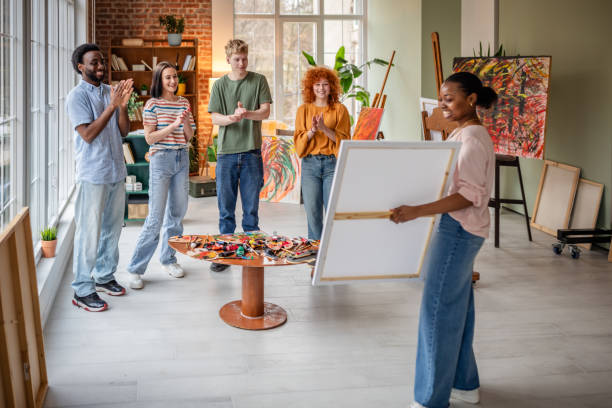 istock Young artists sharing their creative process in a vibrant art studio environment 2206075257