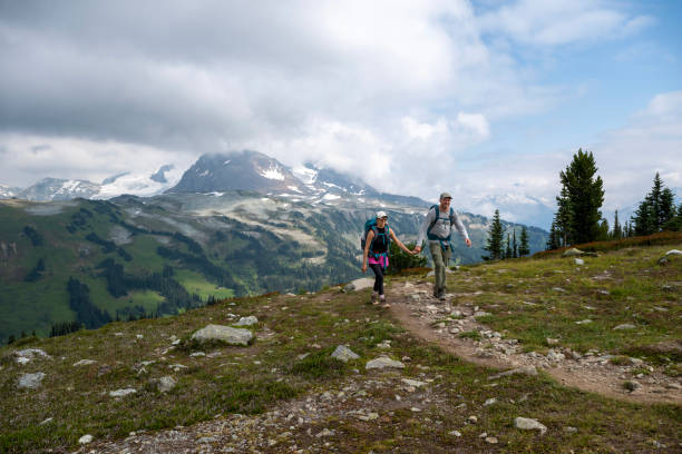 istock Couple hike pathway in mountain meadow 2206075276