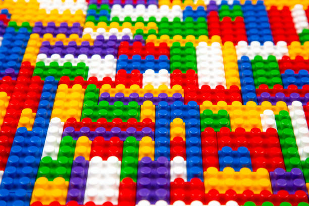 Abstract background texture of colored constructor blocks. Background of colorful plastic part of constructor. Pile of colored toy bricks.