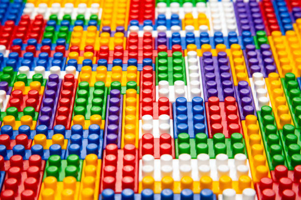 Abstract background texture of colored constructor blocks. Background of colorful plastic part of constructor. Pile of colored toy bricks.