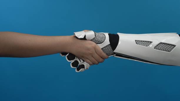 istock Human Hand Shaking with Robotic Prosthetic Hand on Blue Background 2206078963