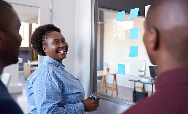 Young African businesspeople strategizing with sticky notes in an office