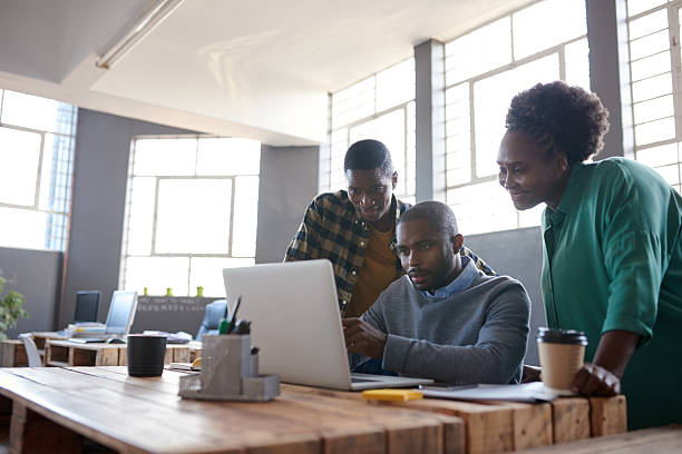 istock African work colleagues using a laptop together in an office 2206080770