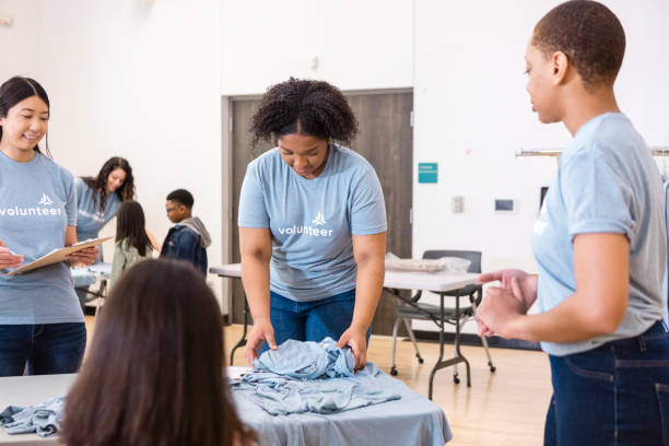 istock Volunteers Folding Clothes at a Charity Event 2206080951
