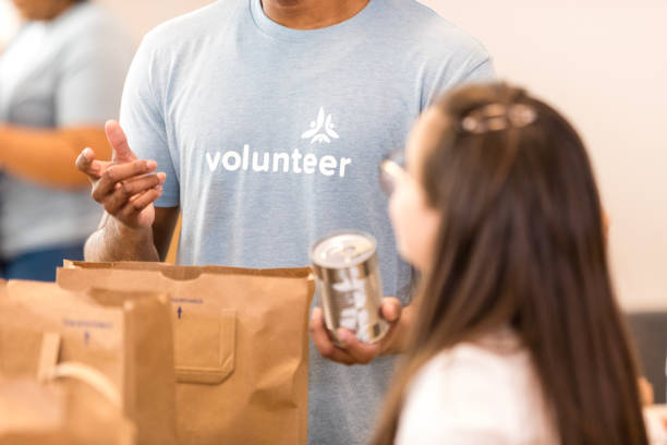istock Volunteer giving canned food, charity work 2206080988