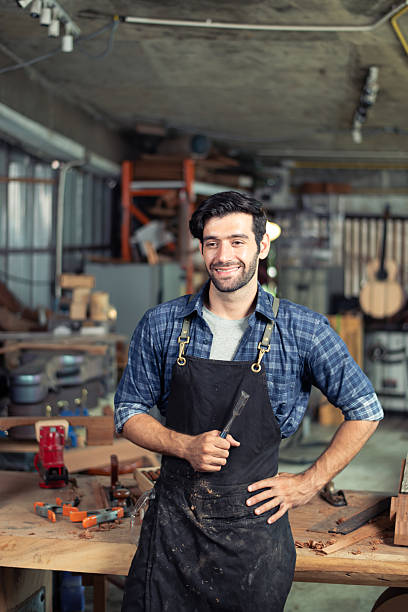 istock Luthier making top of guitar using traditional tools in workroom with manual tools 2206083646